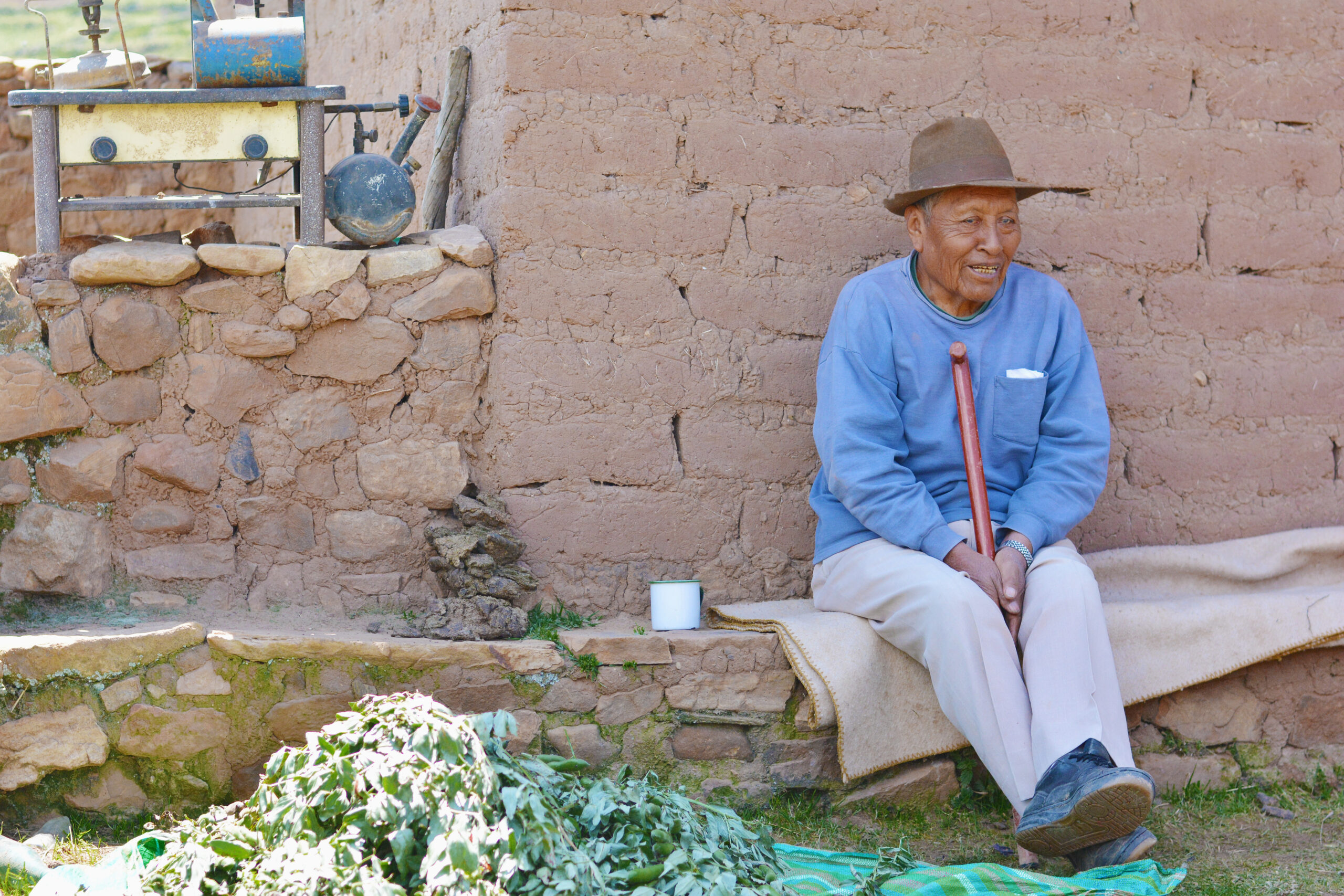 Hombre mayor perteneciente a pueblo indígena sentado afuera de su casa.