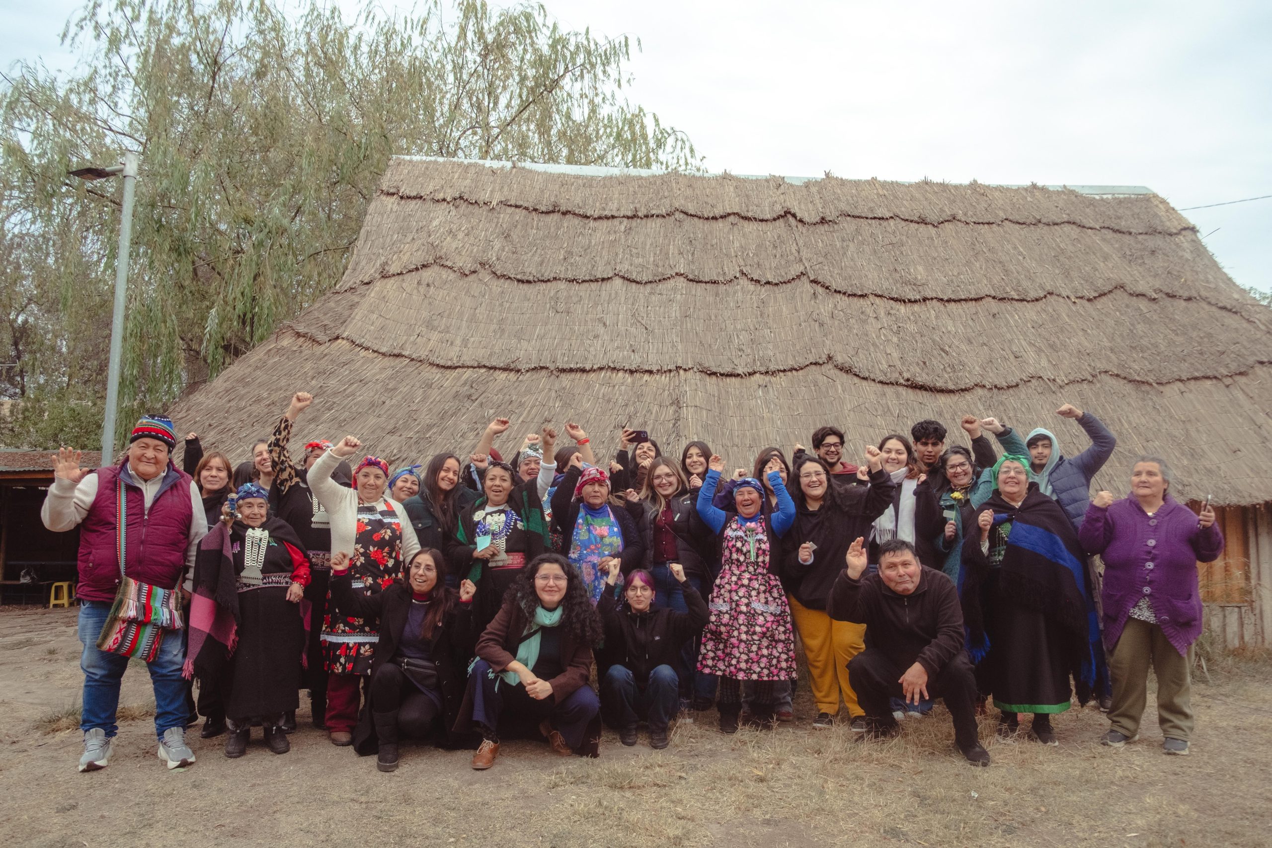 Fotografía con todas y todos los participantes del encuentro intergeneracional Tejiendo saberes, afuera del Centro Ceremonial Mapuche de La Pintana.